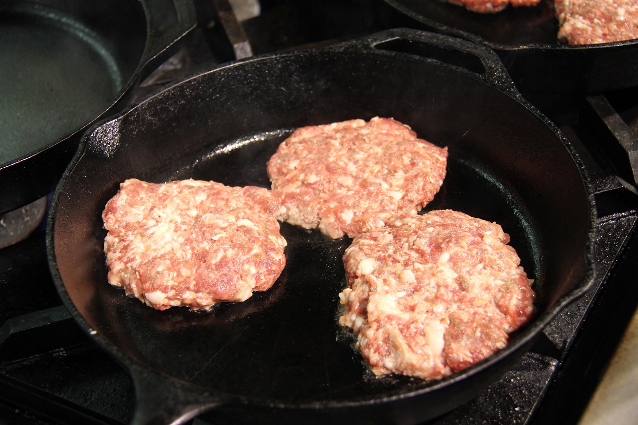 Venison burgers cooking in a cast iron skillet.  Image: Bruce Biermann